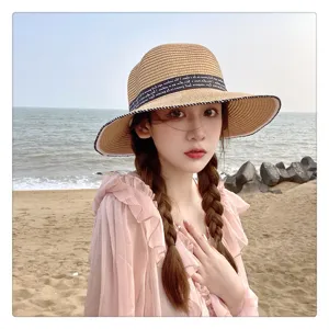Detalles del sombrero de paja de verano con cinta negra, accesorio de playa perfecto.