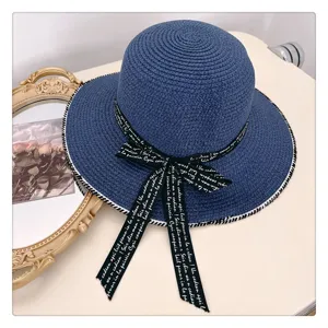 Sombrero de paja plano azul con cinta negra, elegante tocado de playa de verano perfecto.