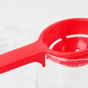Creative red plastic egg white separator with hook handle for easy bowl edge placement.