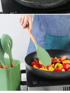 Siliconen kookspatel en keukengerei set in gebruik, detailopname van koken in de pan.