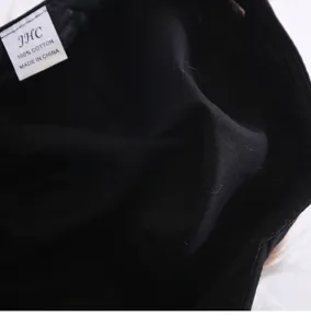 Detail view displaying the interior washing label and black fabric of the wig baseball cap.