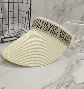 Detailansicht des beigen Stroh-Sonnenschirms mit stilvollem Buchstabenband, Strandhut.