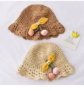 Gros plan de charmants chapeaux de soleil pour enfants tressés avec joli décor de cerise.