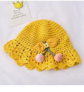 Vue detaillee du chapeau de paille jaune pour bebe avec un beau nœud rose estival.