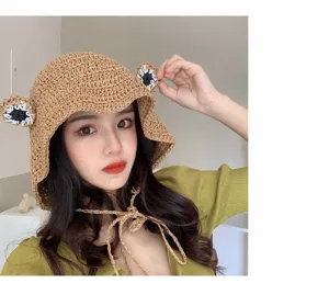 Close-up detail of a cute handmade crochet straw hat with frog ears, ideal for summer sun protection.