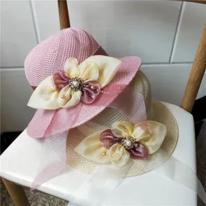 Primo piano dettaglio del cappello da sole estivo da donna in paglia traforata e perle.