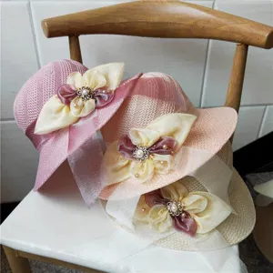 Dettaglio cappello di paglia estivo pieghevole, design intrecciato con fiocco e perla.