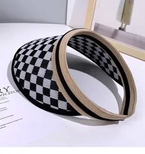 Gros plan sur la visière à carreaux noir et blanc, chapeau d'été tissé avec dessus ouvert.