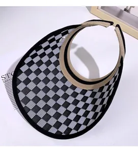 Détail de visière pare-soleil à carreaux noirs et blancs avec texture tricotée et bord beige.