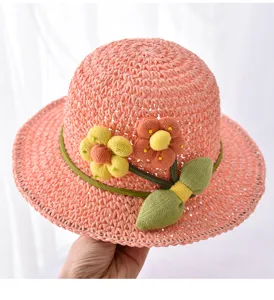Detailansicht des niedlichen Kinder Strohhutes mit Strickblumen fur sonnige Tage.