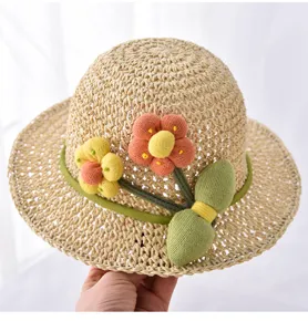 Detailansicht des Kinder Strohhuts mit süßen Stoffblumen und luftigem geflochtenem Stroh.