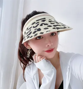 Close-up detail of the stylish straw sun visor hat with chic animal print design.
