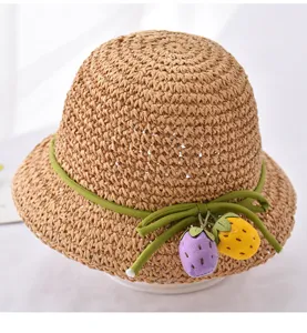 Detailaufnahme des süßen Kinderstrohhats mit geflochtener Textur und Sommerobstdekor.