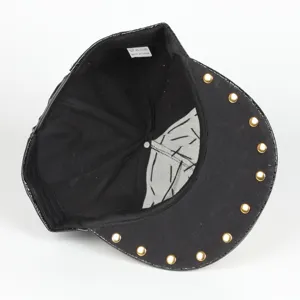 Vista detallada de la gorra snapback punk negra con tachuelas doradas en el borde de la visera.