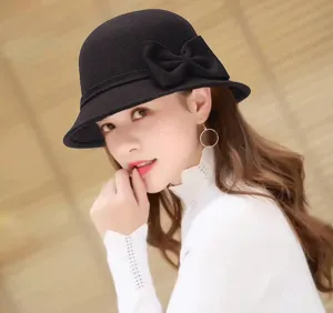 Detail view of stylish black wool bucket hat with elegant bow knot worn by model.