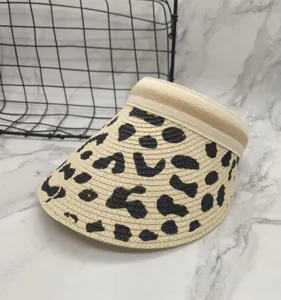 Detailed view of the stylish cow print straw sun visor hat, perfect for summer outdoor wear.
