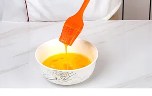 Silicone oil brush for baking, flexible kitchen BBQ tool detail view showing orange design.