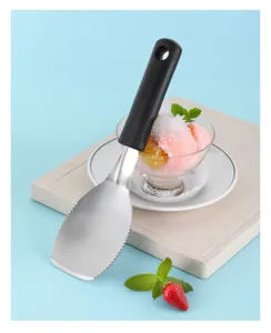Stainless steel ice cream spade detail, featuring serrated edge and black handle for kitchen.