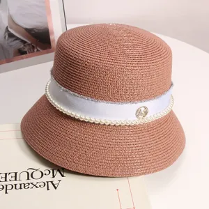 Elegante cappello a secchiello in paglia con nastro bianco di perle e ciondolo M in metallo.