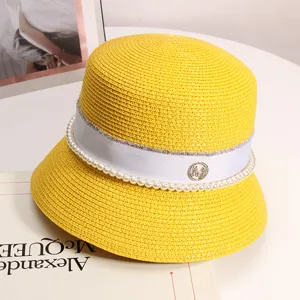 Vista dettagliata dell'elegante cappello in paglia gialla con nastro di perle e ciondolo M.