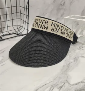 Nahaufnahme eines stilvollen schwarzen Stroh-Sonnendarmbänder mit beigem Buchstabenband.