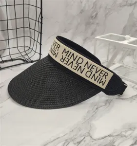 Nahaufnahme eines schwarzen Stroh-Sonnenschirms mit stilvollem Buchstaben-Band für den Sommer.