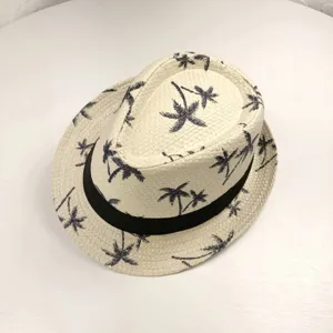 Gros plan détaillé du chapeau fedora en paille avec texture tissée fine et motif de palmier.