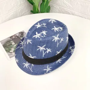 Chapeau fedora en paille bleue avec imprime palmier blanc et ruban noir pour plage d'ete.