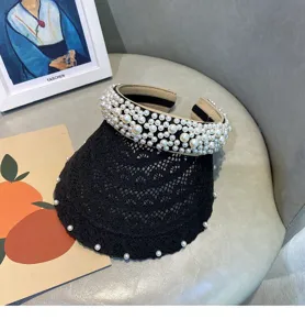 Detailed view of black lace pearl sun visor, elegant empty top hat for women summer vacation.