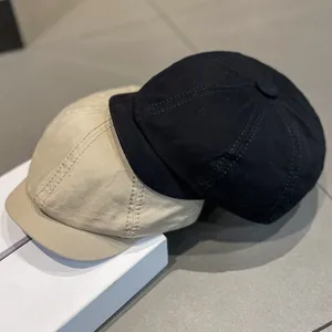 Close-up detail display of two docker caps, black and khaki cotton brimless hats showcase.