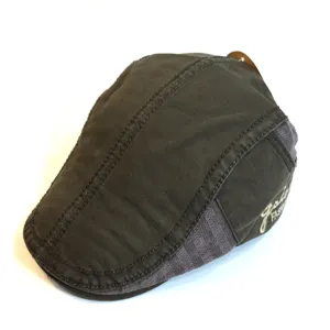 Detail view of dark green cotton ivy flat cap, classic casual newsboy hat with side embroidery.