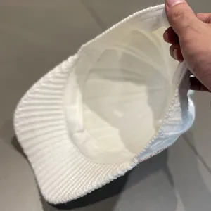 Vue détaillée montrant la structure intérieure de la casquette tricotée et des strass.