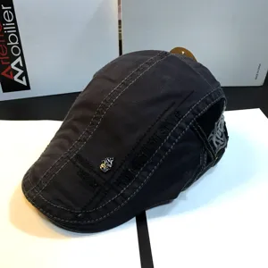 Stylish black flat cap beret for men and women, featuring metal skull and cool embroidery details.