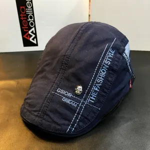 Navy blue denim ivy cap with skull rivet and embroidered text for men and women fashion.