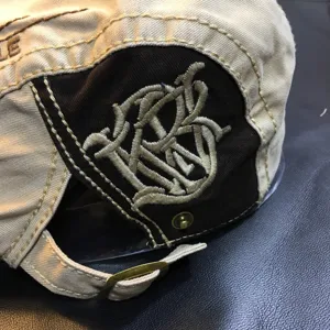 Classic canvas flat cap for men and women, featuring detailed embroidery and adjustable strap.