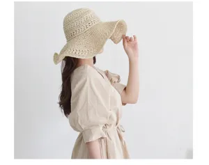 Detail view of a beige wide-brim straw hat, perfect for summer beach vacation and sun protection.