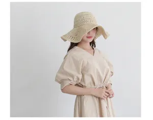 Detail view of a stylish women's wide brim straw sun hat, perfect for beach summer outfits.