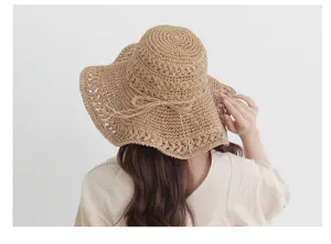 Detail view of woven straw sun hat back, wide brim bohemian style summer beach holiday hat.