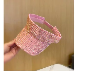 Vista dettagliata di una elegante visiera parasole rosa brillante con strass per l'estate.