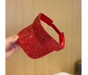 Vista dettagliata di un elegante cappello visiera rosso con strass, design scintillante.