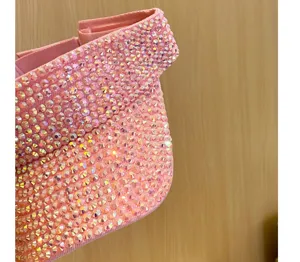 Dettaglio di visiera rosa scintillante con strass, elegante cappello estivo parasole.