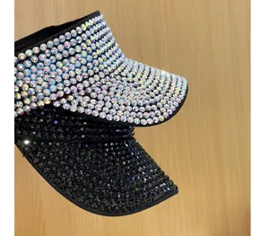 Primo piano di visiere parasole in strass scintillanti, nere e di cristallo impilate.