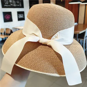 Chapeau de paille vintage style Hepburn pour femme avec ruban nœud papillon blanc.