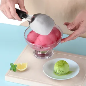 Stainless steel ice cream scoop with serrated edge and ergonomic handle for kitchen dessert use.