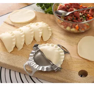 Stainless steel dumpling maker detail showing manual operation with wrappers and filling.