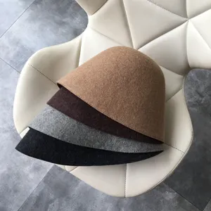 Detailed view of stacked wool felt bucket hats in multi-colors like black, gray, camel.