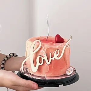 Wooden love cake topper detail view for Valentine's day cake decoration and romantic party.