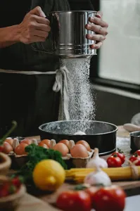 Tamiz de harina manual de acero inoxidable en acción, colador de malla fina para pasteles y azúcar.