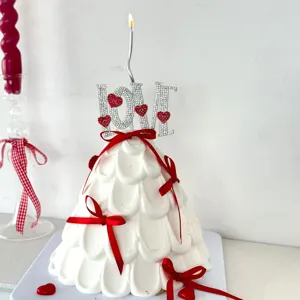 Rhinestone love letter cake topper with candle and red ribbon for Valentine's day decor.