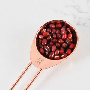 Cuillère à mesure en acier inoxydable or rose pour la pâtisserie et cuisine précise.
